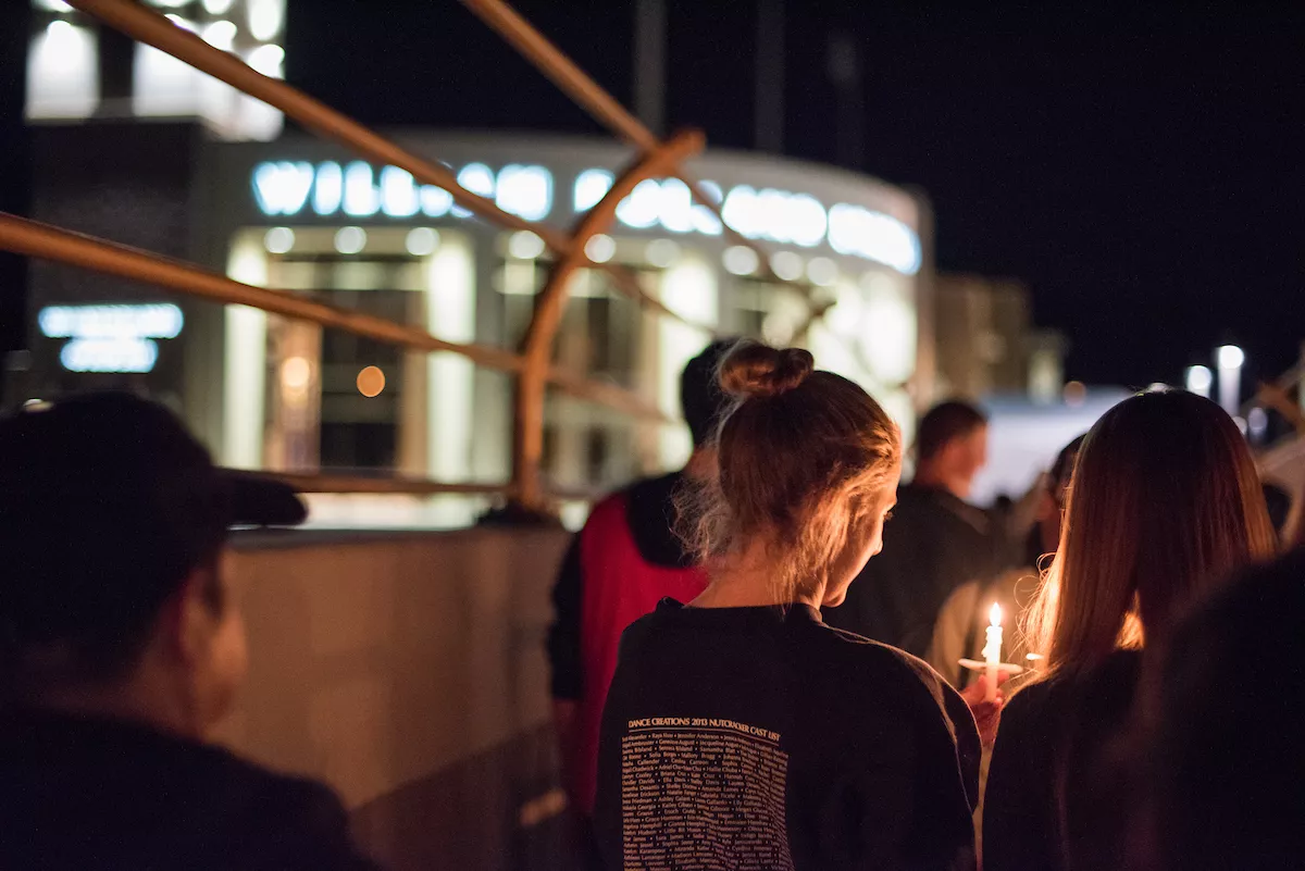 Student walking with candlelight